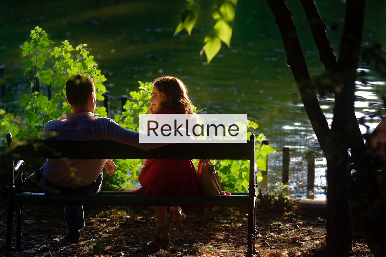 Et par sidder på en bænk i naturen